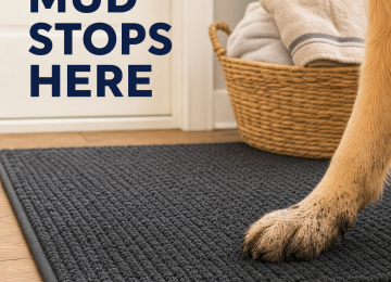 Alternative Text: Muddy golden retriever paw resting on a textured charcoal doormat beside a towel basket.